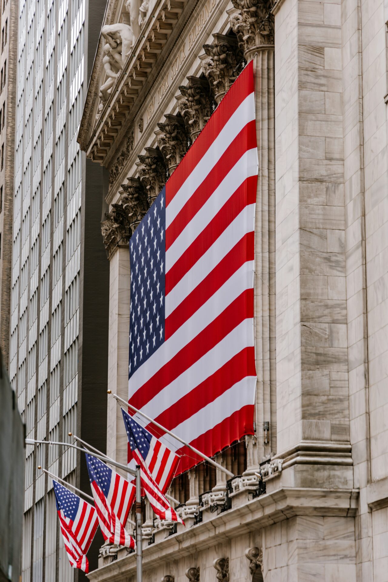 a large american flag hanging from the side of a building