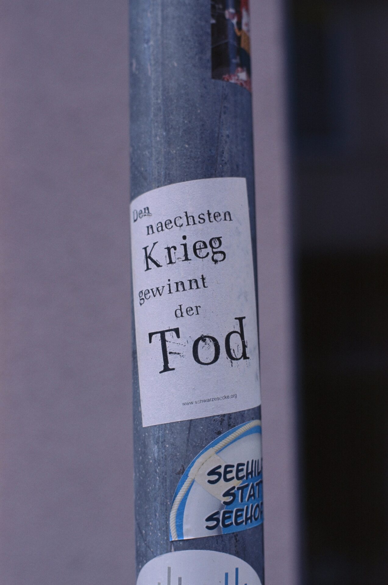 a sticker on a pole with a message on it