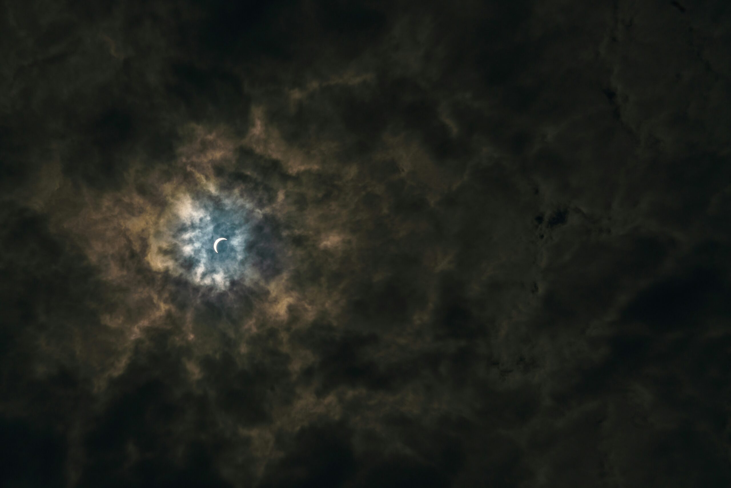 half moon surrounded by brown clouds