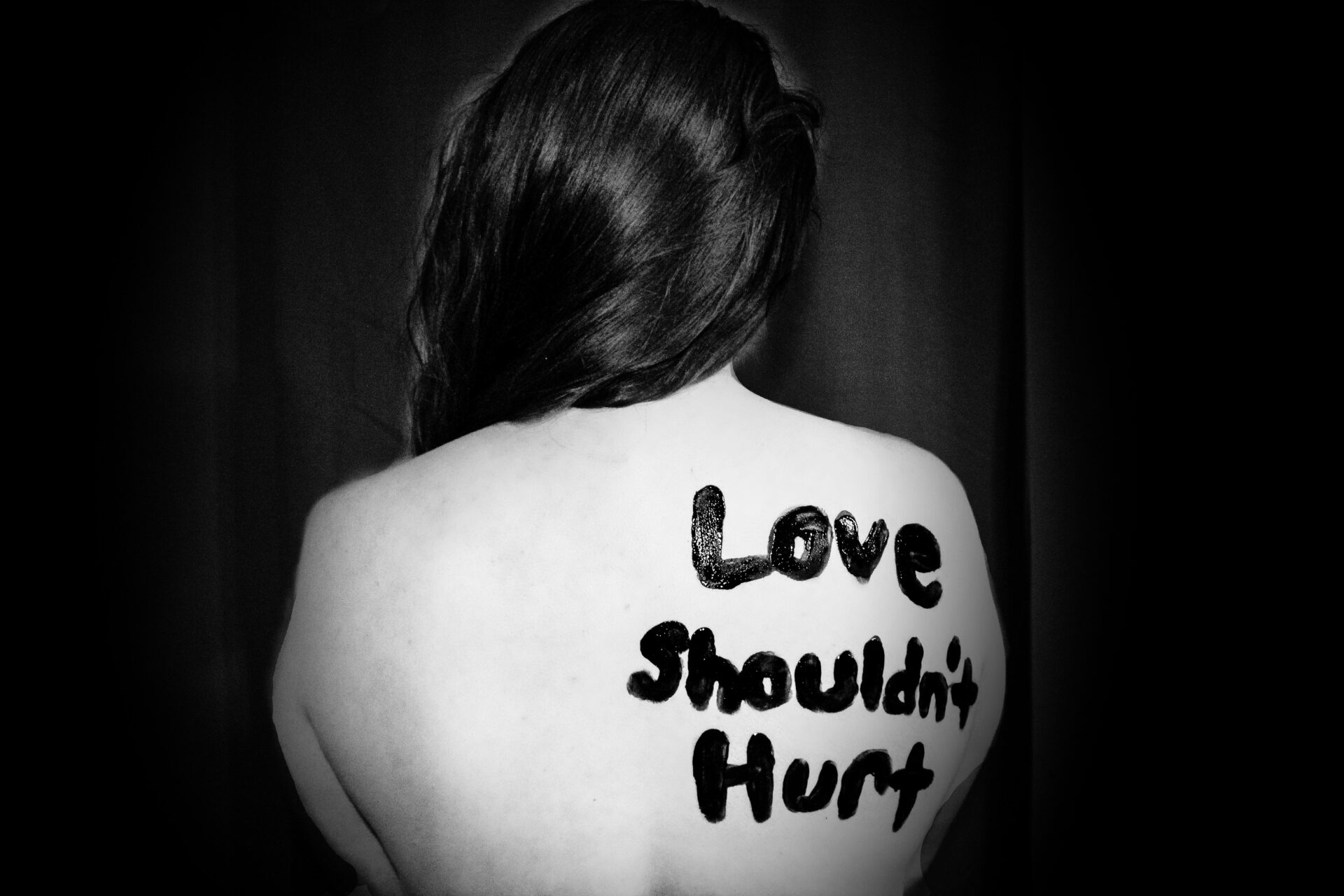 love shouldn't hurt-printed on back of woman