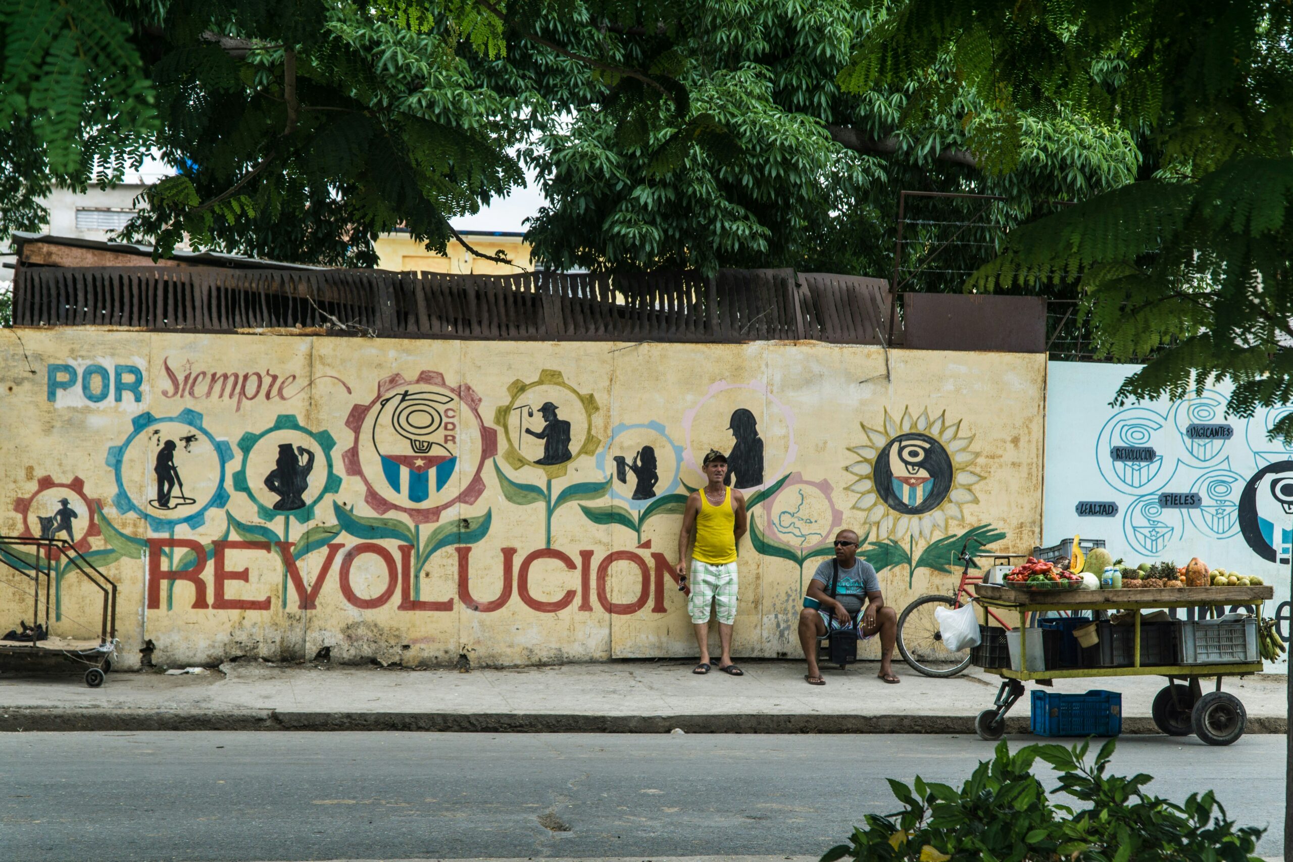 two men standing near wall with mural