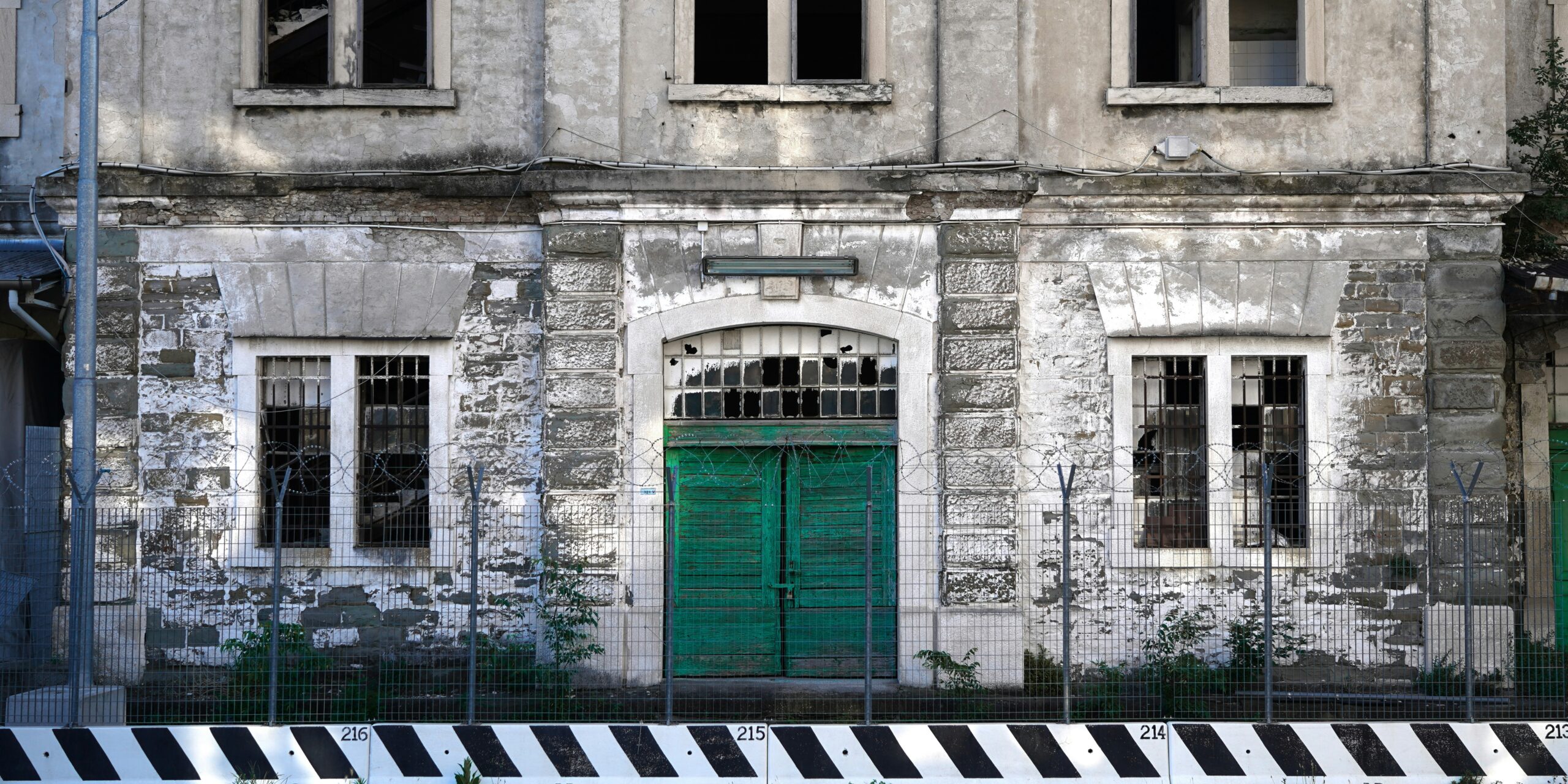 white concrete building with green wooden door